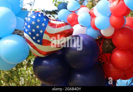 Présentation festive et lumineuse de ballons rouges, blancs et bleus avec le drapeau américain en évidence le jour de l'indépendance. Banque D'Images