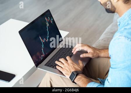Gros plan sur la main masculine travaillant sur ordinateur portable avec graphique de bougie pour le marché boursier Banque D'Images