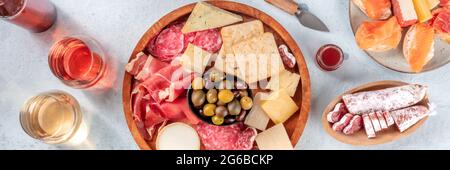 Panorama des antipasti italiens ou des tapas espagnols. Assiette de charcuterie et fromage gastronomique, prise du dessus avec vin et sandwichs. Une variété de hors-d'œuvre Banque D'Images