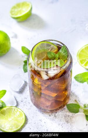 Boisson fraîche d'été rafraîchissante. Boisson alcoolisée Cuba libre, Cola avec glaçons sur table en pierre grise. Banque D'Images
