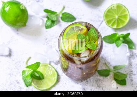 Boisson fraîche d'été rafraîchissante. Boisson alcoolisée Cuba libre, Cola avec glaçons sur table en pierre grise. Banque D'Images