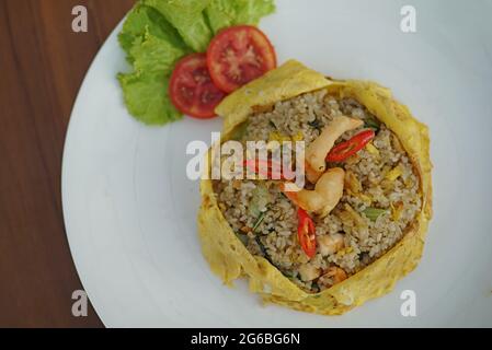 Le nasi Pattaya, est un plat de riz frit d'Asie du Sud-est fait en couvrant ou en enveloppant le riz frit au poulet, dans un œuf ou une omelette frits. Banque D'Images