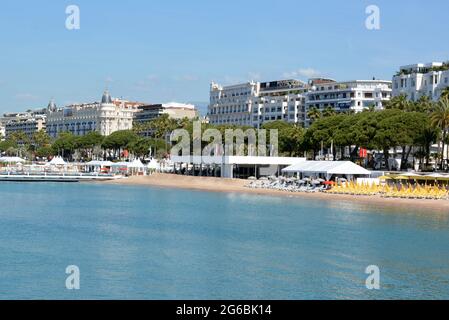 France, Cannes, Boulevard Croisette, hôtels de luxe, plages de sable avec parasols multicolores et chaises longues. Banque D'Images