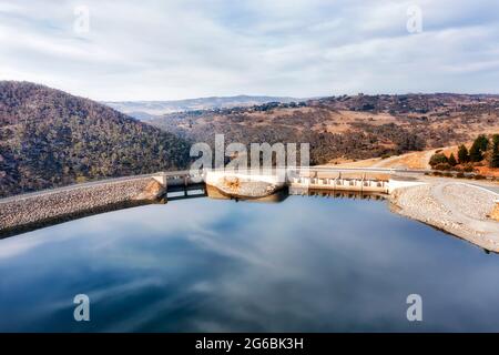 Immense barrage hydro-énergétique en béton sur la rivière Snowy formant le lac Jindabyne - vue aérienne sur la porte d'obturation et la route. Banque D'Images