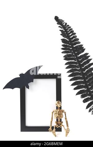 Maquette de cadre verticale noire. Photos de stock stylisées. Halloween concept avec détails stylés squelette et feuilles noires. Banque D'Images