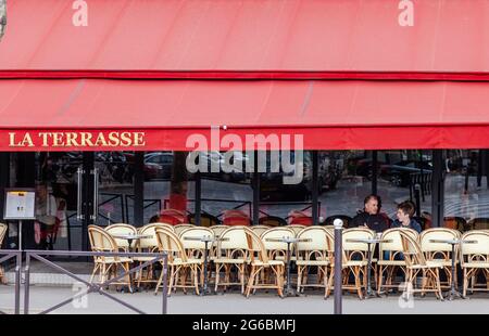 Père et fils assis sur la terrasse d'un bistro parisien Banque D'Images