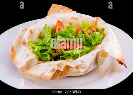 Salade chaude dans du pain pita fin: Boeuf, champignons, tomates cerises, moutarde de Dijon, cognac. Isolé sur fond noir Banque D'Images