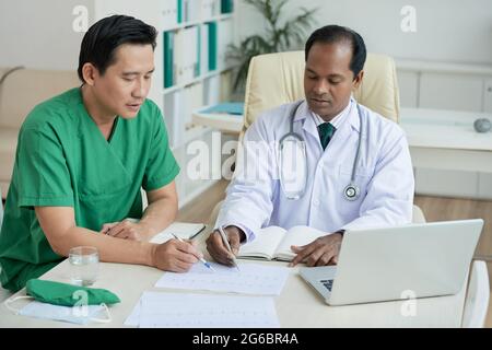 Cardiologue et généraliste discutant du cardiogramme d'un patient atteint d'une maladie cardiaque Banque D'Images