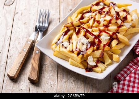 Poutine canadien traditionnel sur une table en bois Banque D'Images