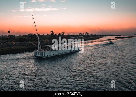 Louxor, Égypte - 3 avril 2021 - bateau touristique sur le Nil au coucher du soleil Banque D'Images