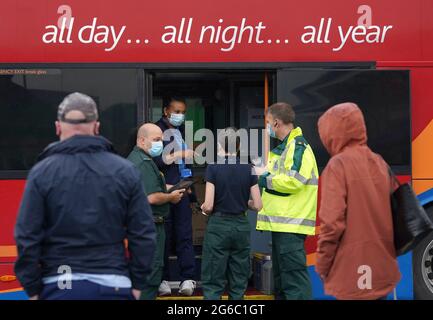 Les membres du public font la queue devant un bus de vaccination contre les covidés au centre commercial Forge de Glasgow. L'unité mobile de vaccination dirigée par le Scottish Ambulance Service visitera les communautés locales et les centres urbains très fréquentés d'Edimbourg et de Glasgow pendant deux semaines. Date de la photo: Lundi 5 juillet 2021. Banque D'Images