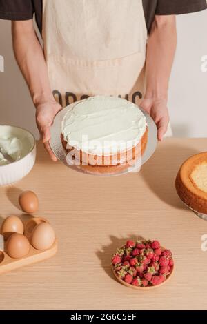 Le chef pâtissier est en possession de gâteau éponge avec de nombreux ingrédients. Processus de fabrication de gâteau éponge Banque D'Images