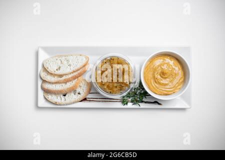 gros plan du pâté de foie d'oie avec des chutneys de pomme et du pain sur fond blanc Banque D'Images