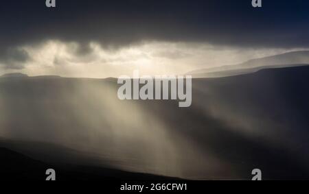 Soleil qui brille à travers les nuages de pluie lors d'une journée d'hiver, Wensleydale, North Yorkshire, Royaume-Uni. Banque D'Images