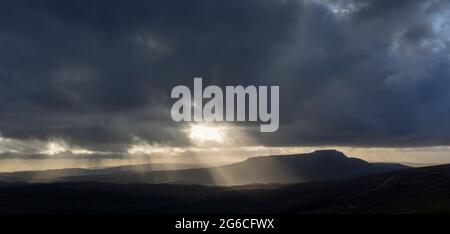 Soleil qui brille à travers les nuages de pluie lors d'une journée d'hiver, Wensleydale, North Yorkshire, Royaume-Uni. Banque D'Images