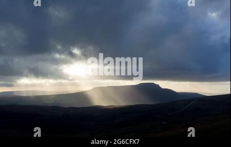 Soleil qui brille à travers les nuages de pluie lors d'une journée d'hiver, Wensleydale, North Yorkshire, Royaume-Uni. Banque D'Images