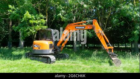 La pelle sur chenilles DX63 de Doosan travaille ici dans une zone de parc. Banque D'Images