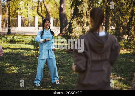 Instructeur de Chineses tai chi gymnastique montrant la pose aux apprenants Banque D'Images