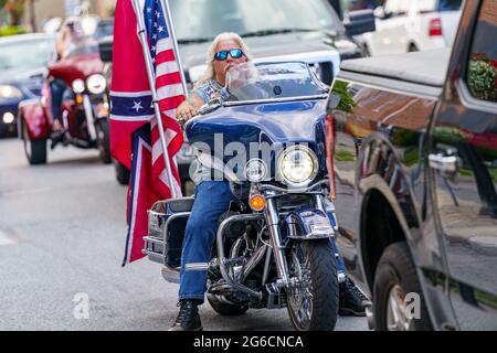 Gettysburg, PA, Etats-Unis - 4 juillet 2021 : un motocycliste dans le centre-ville affichant les drapeaux des Etats-Unis et de la Confédération. Banque D'Images