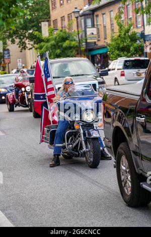 Gettysburg, PA, Etats-Unis - 4 juillet 2021 : un motocycliste dans le centre-ville affichant les drapeaux des Etats-Unis et de la Confédération. Banque D'Images