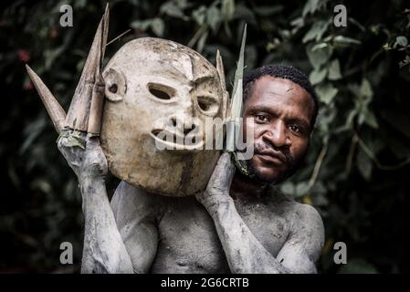 Un Mudman tenant son masque couvert de boue. PAPOUASIE-NOUVELLE-GUINÉE : CE PHOTOGRAPHE a partagé des photos d'un festival qui réunit des tribus rivales - Banque D'Images