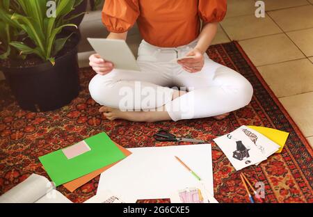 Jeune femme créant son Feng Shui souhaite cartocher sur la moquette dans la chambre en style boho avec beaucoup de plantes. Rêves et souhaits Banque D'Images