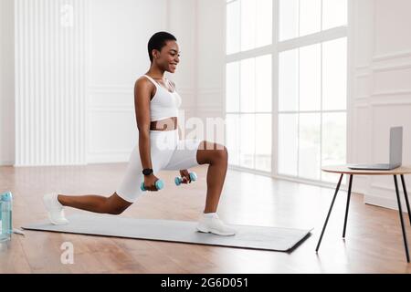 Femme noire faisant des fentes avant devant l'ordinateur portable Banque D'Images