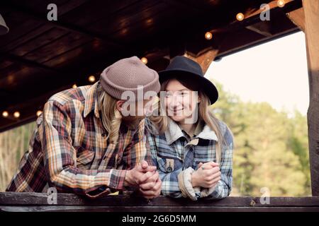 Un couple de jeunes agriculteurs se parlent en se tenant debout sur la terrasse du pays Banque D'Images