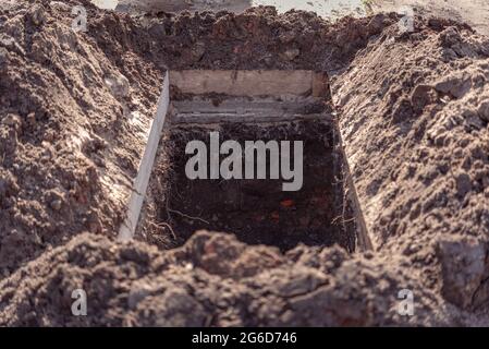 Fosse de sépulture fraîchement creusée au cimetière, un gros plan. Banque D'Images