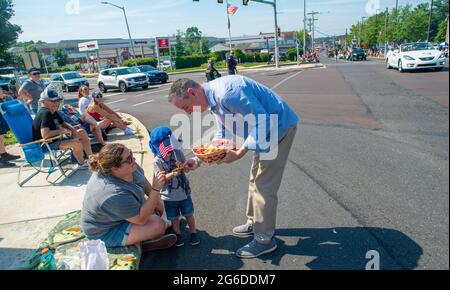 Upper Southampton, États-Unis. 05e juillet 2021. La représentante DES ÉTATS-UNIS Brian Fitzpatrick (R-PA.) remet des bonbons à, de gauche à Jessica Hern et à son fils Ryker Herb, 3 ans, lors de la parade du 4 juillet dans le quartier supérieur de Southampton le lundi 05 juillet 2021 à second Street Pike dans le quartier supérieur de Southampton, Pennsylvanie. Des centaines de personnes ont assisté à la 4e célébration du canton après une absence l'an dernier en raison de la pandémie mondiale. Crédit : William Thomas Cain/Alay Live News Banque D'Images