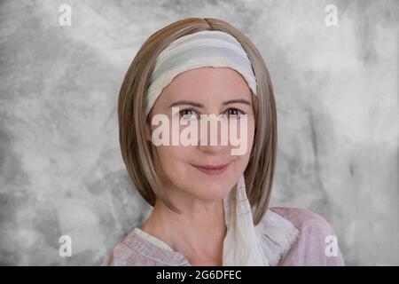 Portrait d'une femme souriante de 50 ans avec un foulard dans les cheveux Banque D'Images