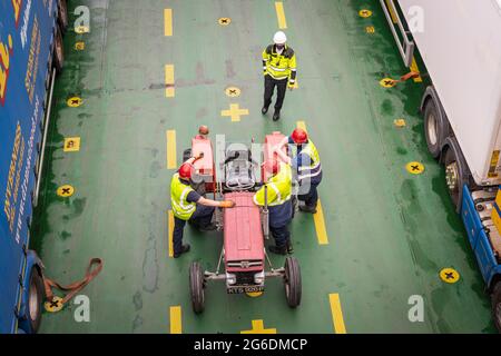 Une image HDR de 3 prises d'un tracteur rouge chargé sur le pont arrière du MacBrayne, « Loch Seaforth » calédonien, en direction de Stornoway. 19 juin 2021 Banque D'Images