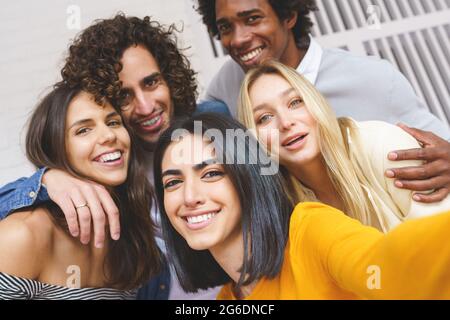 Groupe multi-ethnique d'amis prenant un selfie ensemble tout en s'amusant dehors. Banque D'Images