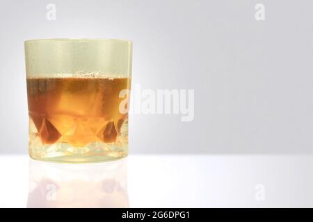 Verre embué avec des gouttes d'eau et whisky avec de la glace. Un verre de whisky sueur avec de la glace sur la table et un espace de copie Banque D'Images