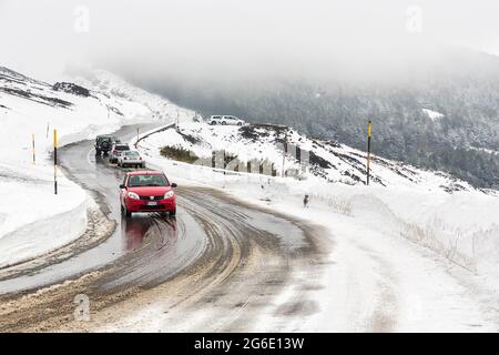 Voiture roulant sur la route sinueuse à travers le paysage brumeux de neige, Silvestri Crater, Etna, Catane, Sicile, Italie Banque D'Images