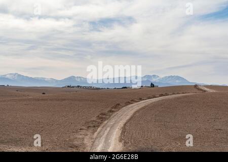 Chemin de terre à travers le désert Agafay menant à l'Atlas, Maroc Banque D'Images