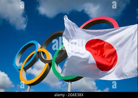 RIO DE JANEIRO - MARS 2016 : un drapeau japonais flotte dans le vent devant les anneaux olympiques debout sous un ciel bleu vif. Banque D'Images