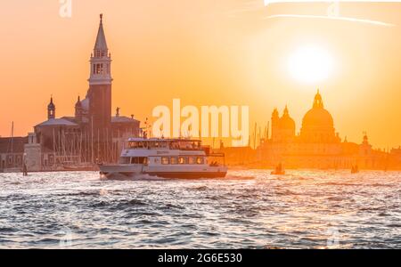 Vaporetto, bateau-bus conduisant sur la lagune de Venise, ambiance du soir, île Isola di San Giorgio Maggiore avec église San Giorgio Maggiore, Basilique Banque D'Images