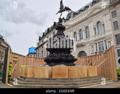 Londres, Royaume-Uni. 05e juillet 2021. Un travailleur a vu monter à bord de la fontaine du Mémorial de Shaftesbury, également connue sous le nom d'Eros, à Piccadilly Circus avant les demi-finales et finales de l'Euro 2020. Le monument de Londres a été embarqué devant les matchs de football restants pour protéger le monument et empêcher les fans de l'escalader. De grandes foules se sont rassemblées sur et autour du monument après les victoires récentes de l'Angleterre dans le championnat de football. Crédit : SOPA Images Limited/Alamy Live News Banque D'Images