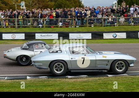 Chevrolet Corvette Sting Ray classique, voiture de course vintage en compétition dans le RAC Tourist Trophy à l'événement historique de Goodwood Revival, Royaume-Uni. Spectateurs Banque D'Images