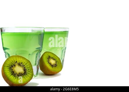 Dessert sucré, gelée de kiwis dans des verres de verre et à côté de kiwis frais, coupé en deux, isoler Banque D'Images