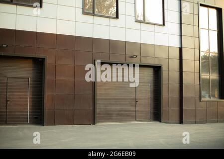 Entrée au garage souterrain. La porte du garage dans le bâtiment. Le bâtiment du bureau est marron. Un panneau de face moderne pour une structure technique Banque D'Images