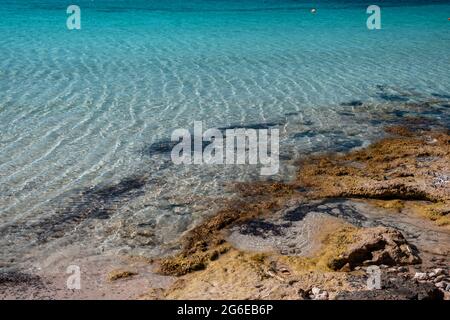 Surface de la mer calme, petites ondulations sur une côte rugueuse, eau peu profonde. Bleu turquoise couleur eau, fond de mer sablonneux et côte rocheuse, vacances d'été dans un paradis Banque D'Images