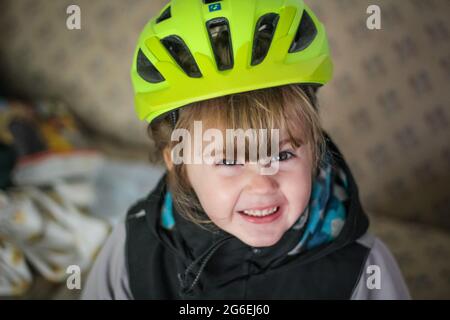 Toddle enfant qui débarque sa moto dans un casque vert Banque D'Images