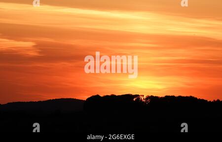 Gros plan sur le coucher du soleil avec des couleurs vives de rouge et d'orange Banque D'Images