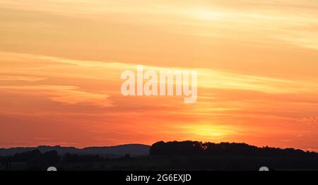 Gros plan sur le coucher du soleil avec des couleurs vives de rouge et d'orange Banque D'Images