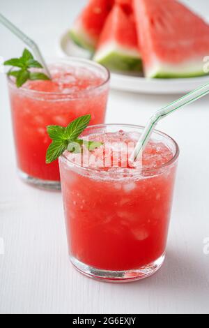 Boisson fraîche d'été avec pastèque et menthe sur fond de bois. Banque D'Images