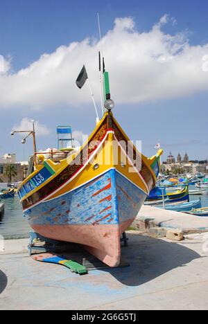 Luzzu, bateau de pêche traditionnel peint dans des couleurs vives avec des yeux typiques sur l'arc, Malte, Marsaxlokk Banque D'Images