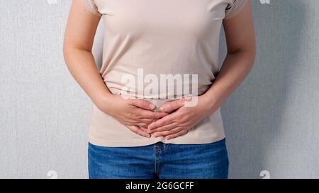 Femme méconnaissable tenant l'estomac en cas de douleur sévère. Banque D'Images