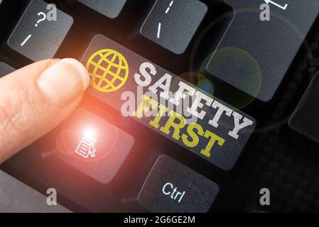 Affiche indiquant la sécurité d'abord. Mot pour éviter tout risque inutile Live en toute sécurité soyez prudent attention Lady doigt montrant-appuyant sur les touches du clavier Banque D'Images